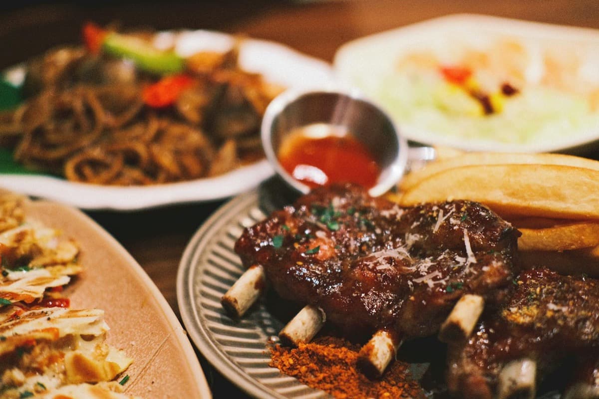 A platter of sauced barbecue ribs served with fries and dipping sauce (16:9)