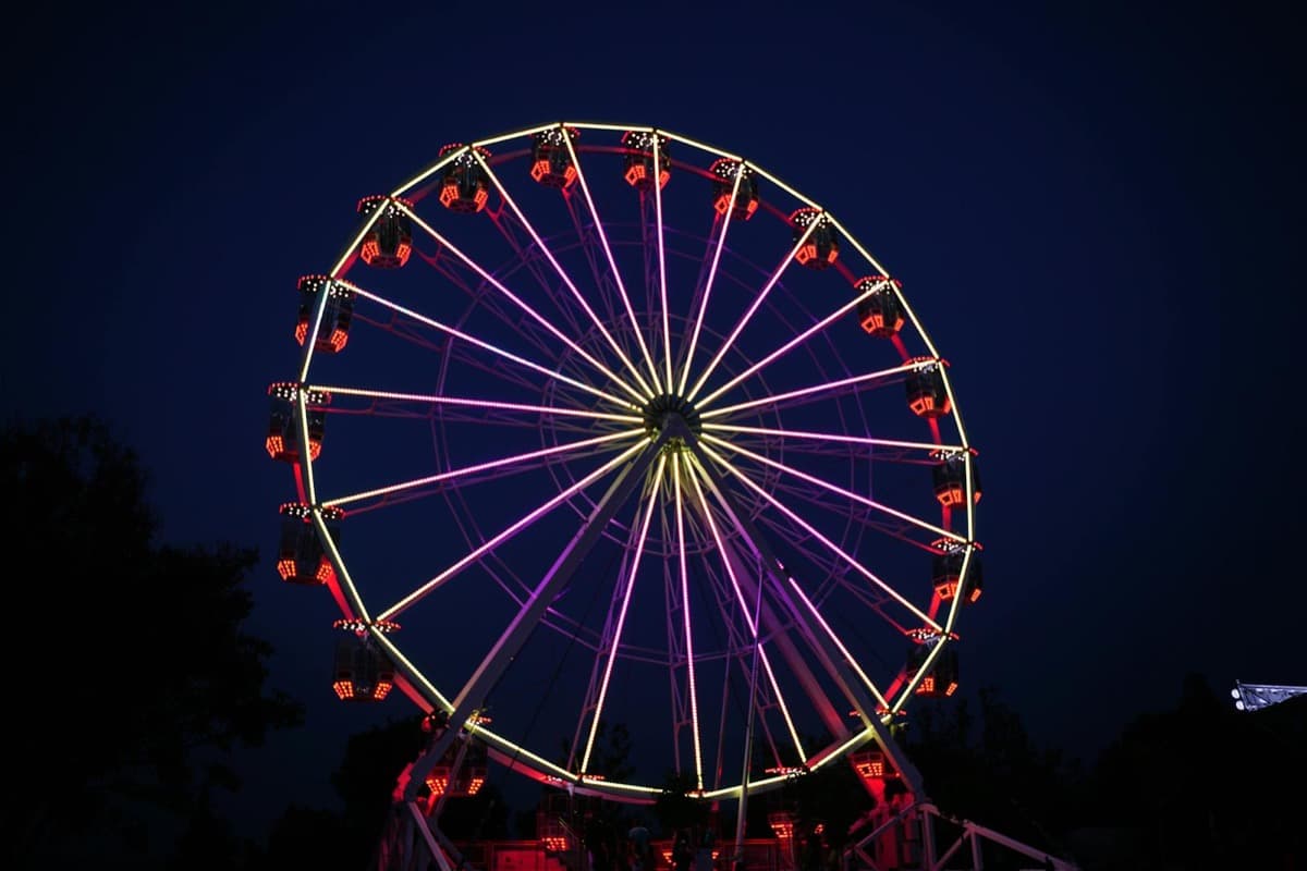 A large illuminated observation wheel glowing against the night sky (16:9)