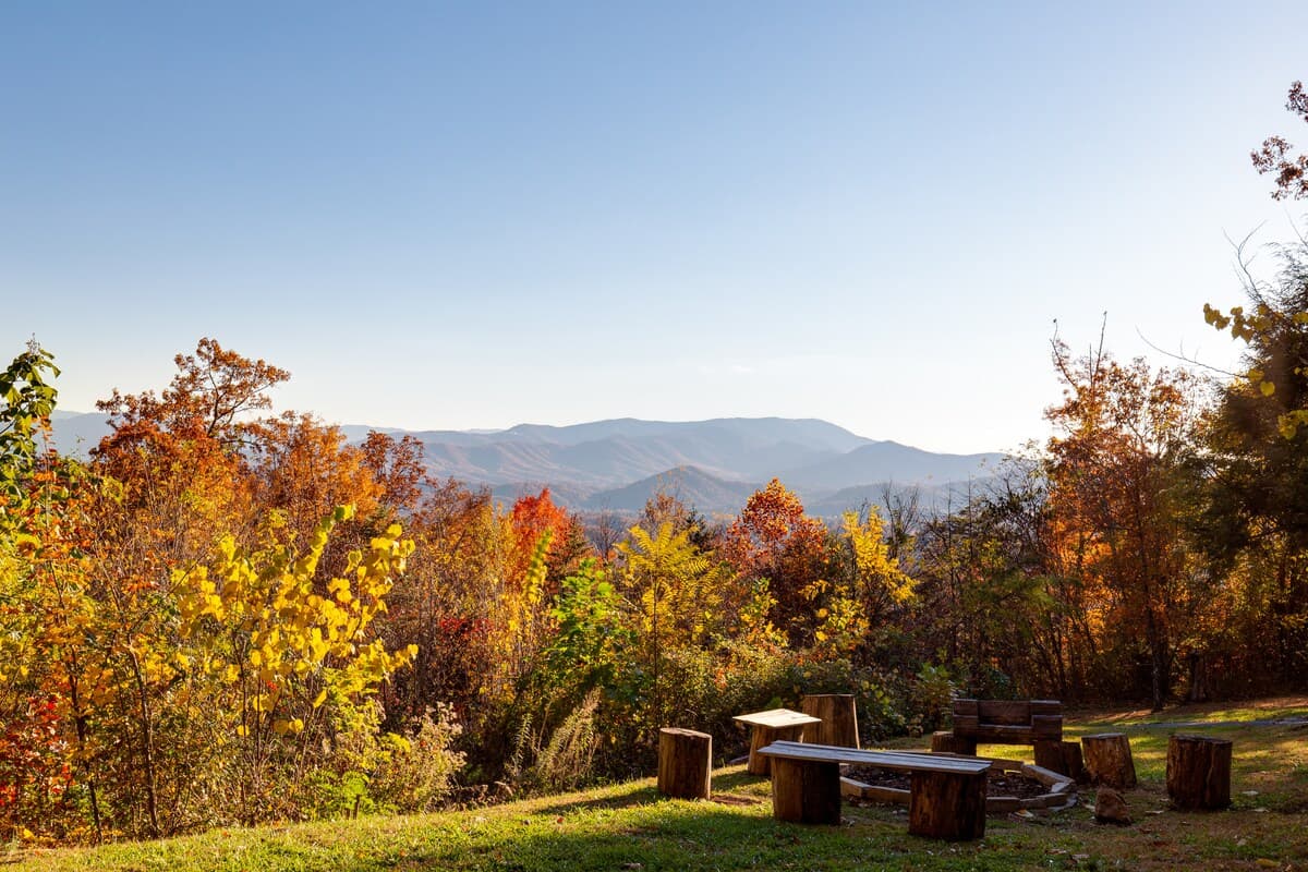 Fire pit area overlooking Smoky Mountain valley surrounded by vibrant red and orange fall foliage