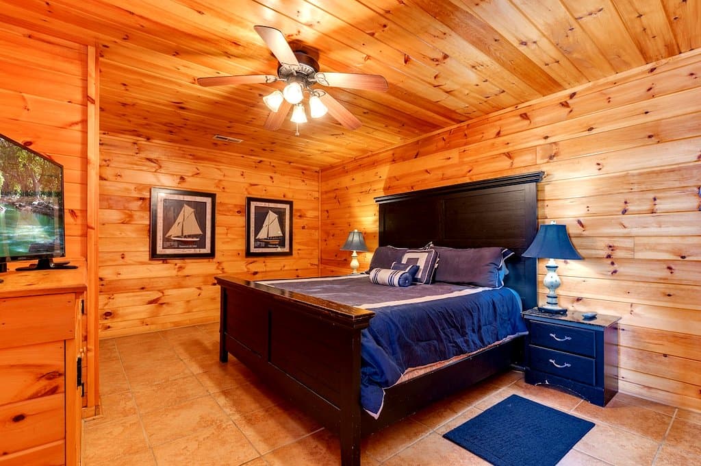 Cabin bedroom with a dark wood bed and blue bedding