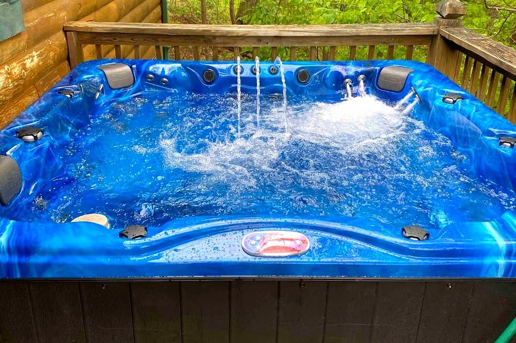 Blue hot tub with bubbling water on the cabin deck
