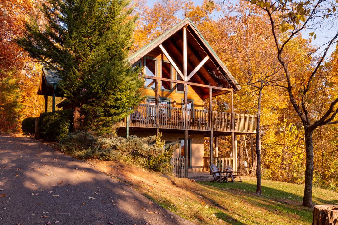 Thistle Britches cabin with expansive deck nestled amongst vibrant autumn foliage and mountain views